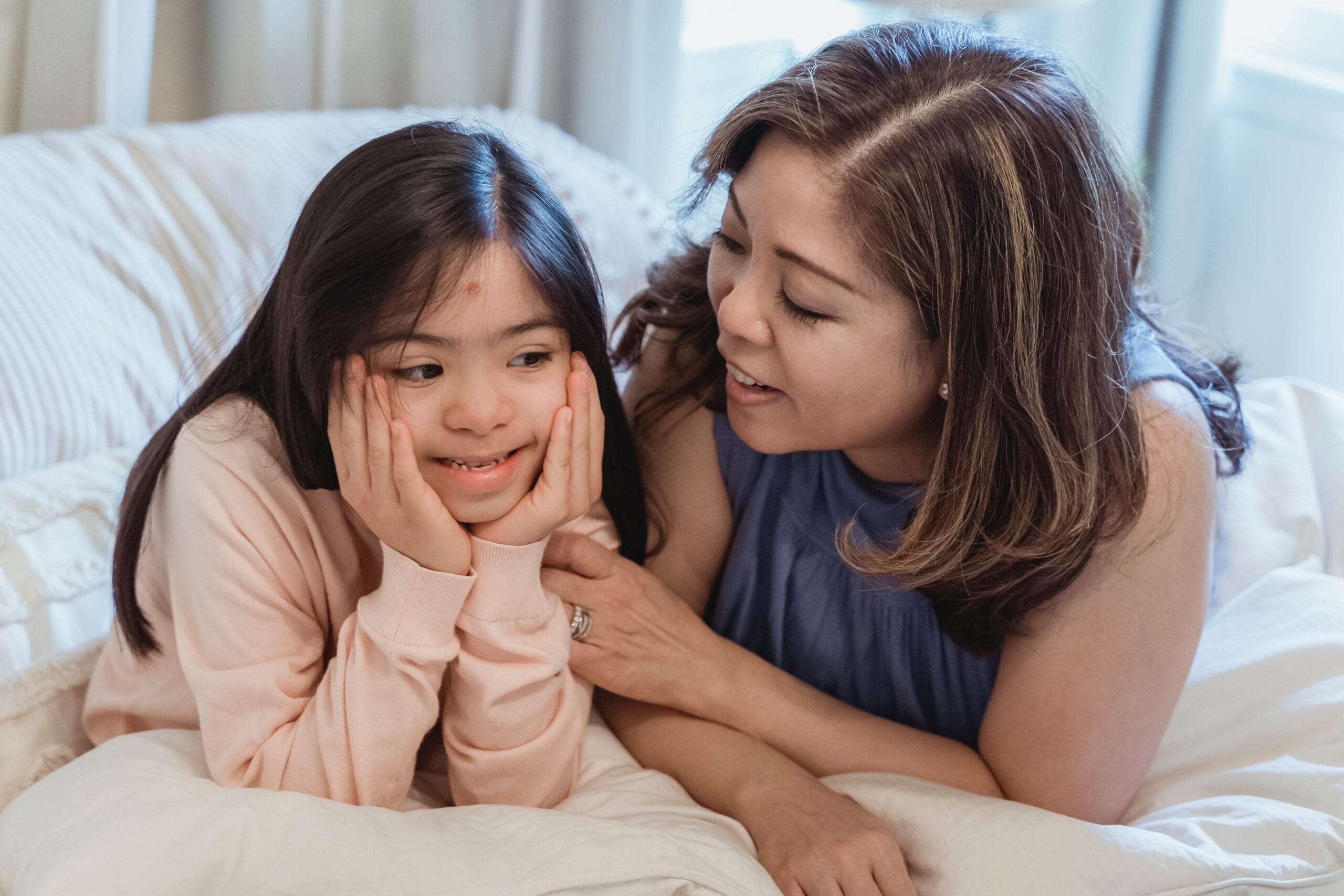 Empathetic nanny engaging in conversation with a special needs girl, exemplifying Lifetime of Love Nannies' commitment to individualized attention, tailored care