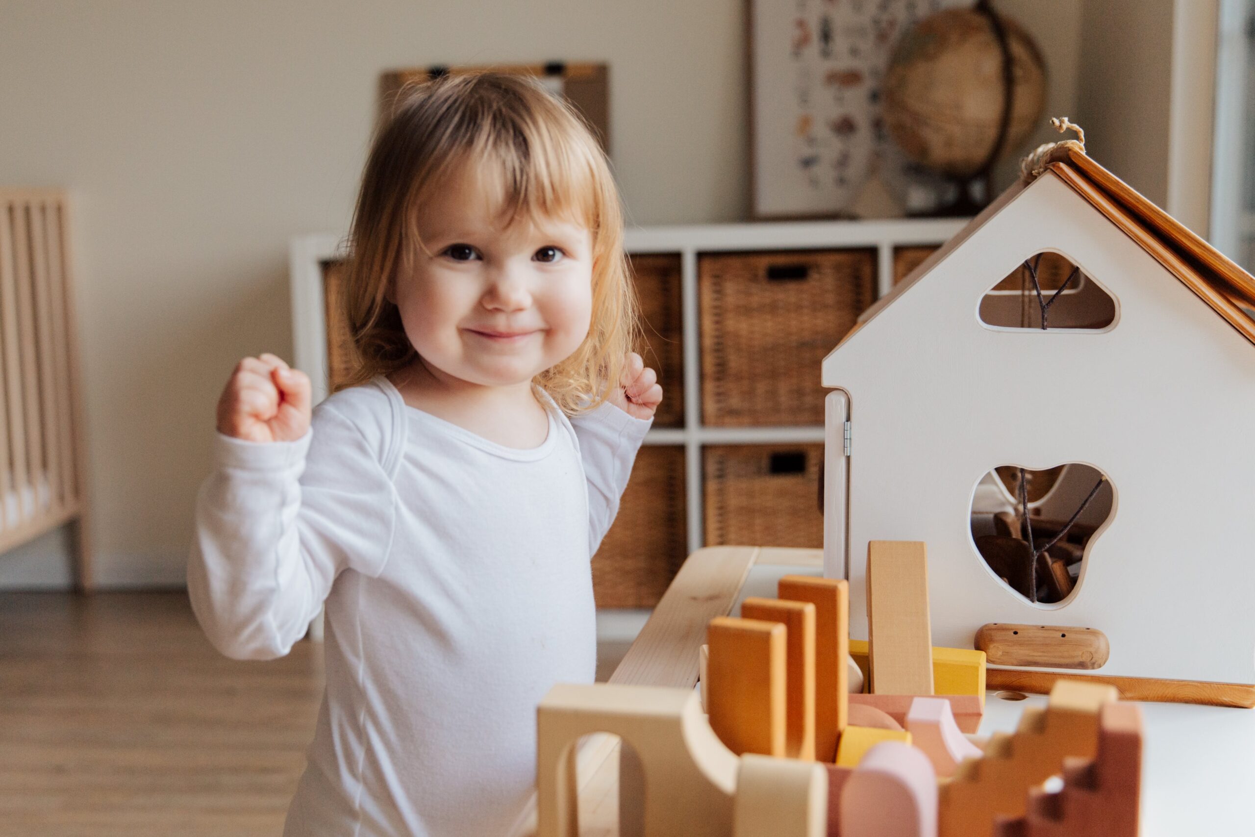 Happy little girl engaged in play with educational toys, exemplifying the experienced and trustworthy childcare provided by Lifetime of Love Nannies' On Call Babysitters