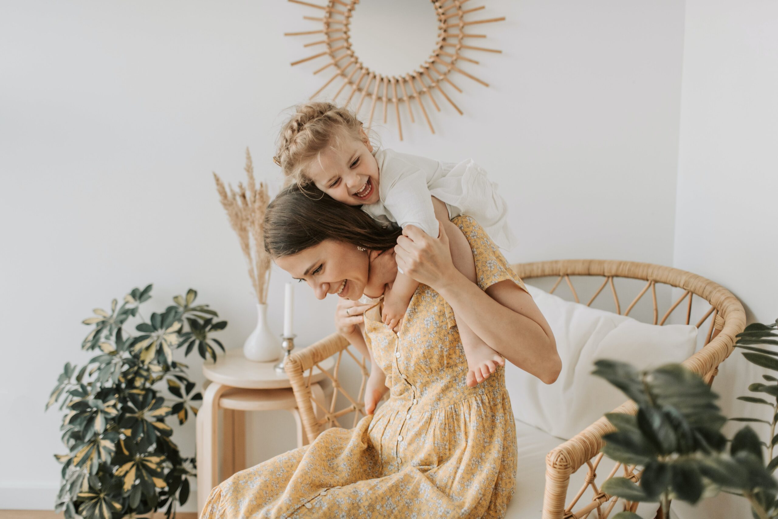 Joyful little girl warmly hugging her nanny from behind, showcasing the personalized and affectionate childcare provided by Lifetime of Love Nannies