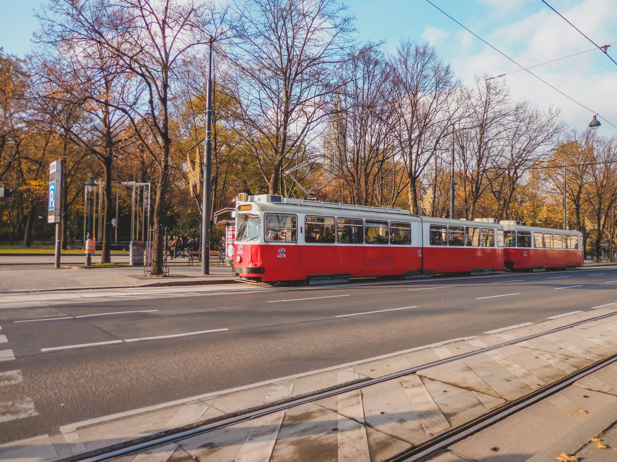 Streetcar traveling through a tree lined urban neighborhood in autumn