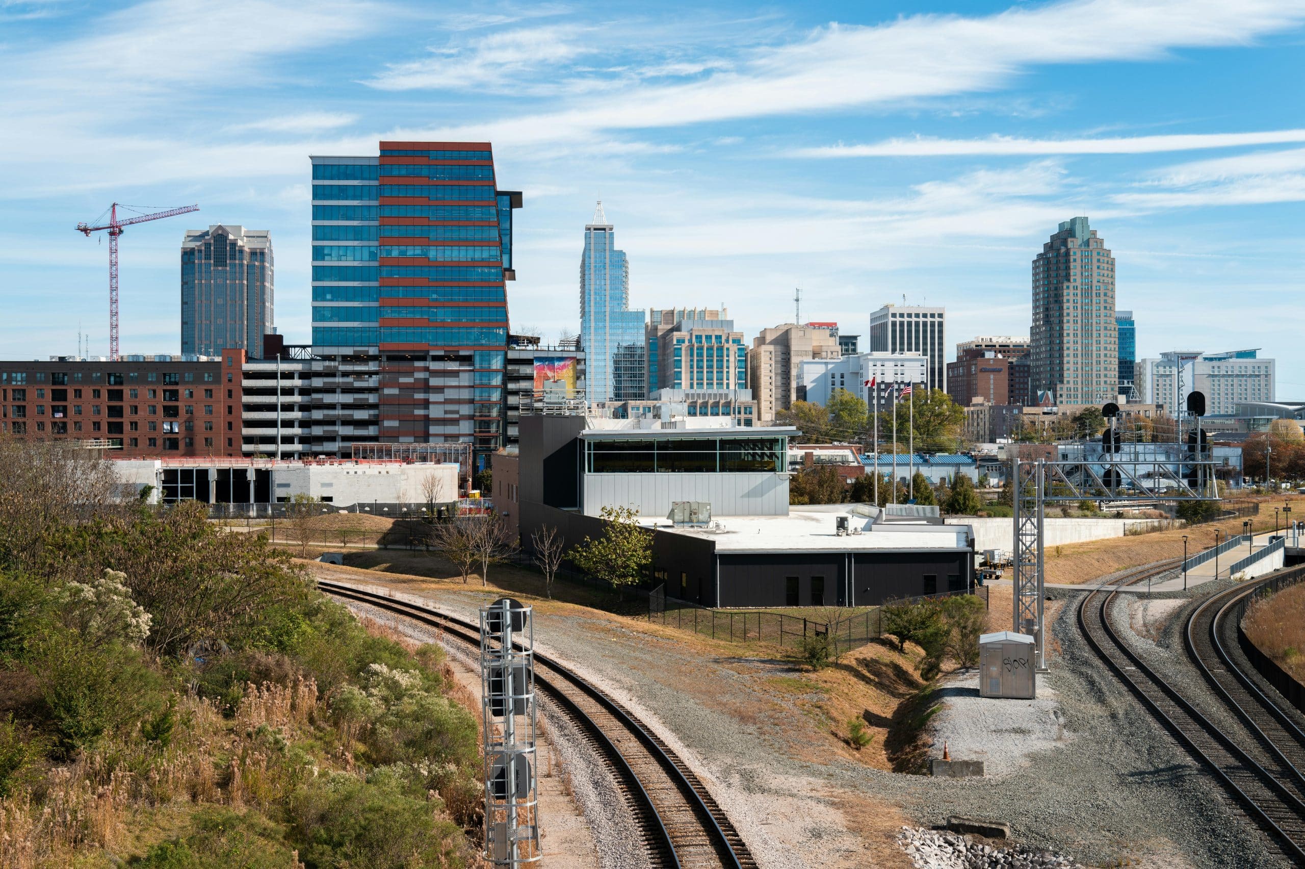 View of the Raleigh skyline from the train tracks, highlighting the vibrant city we proudly serve with trusted childcare.