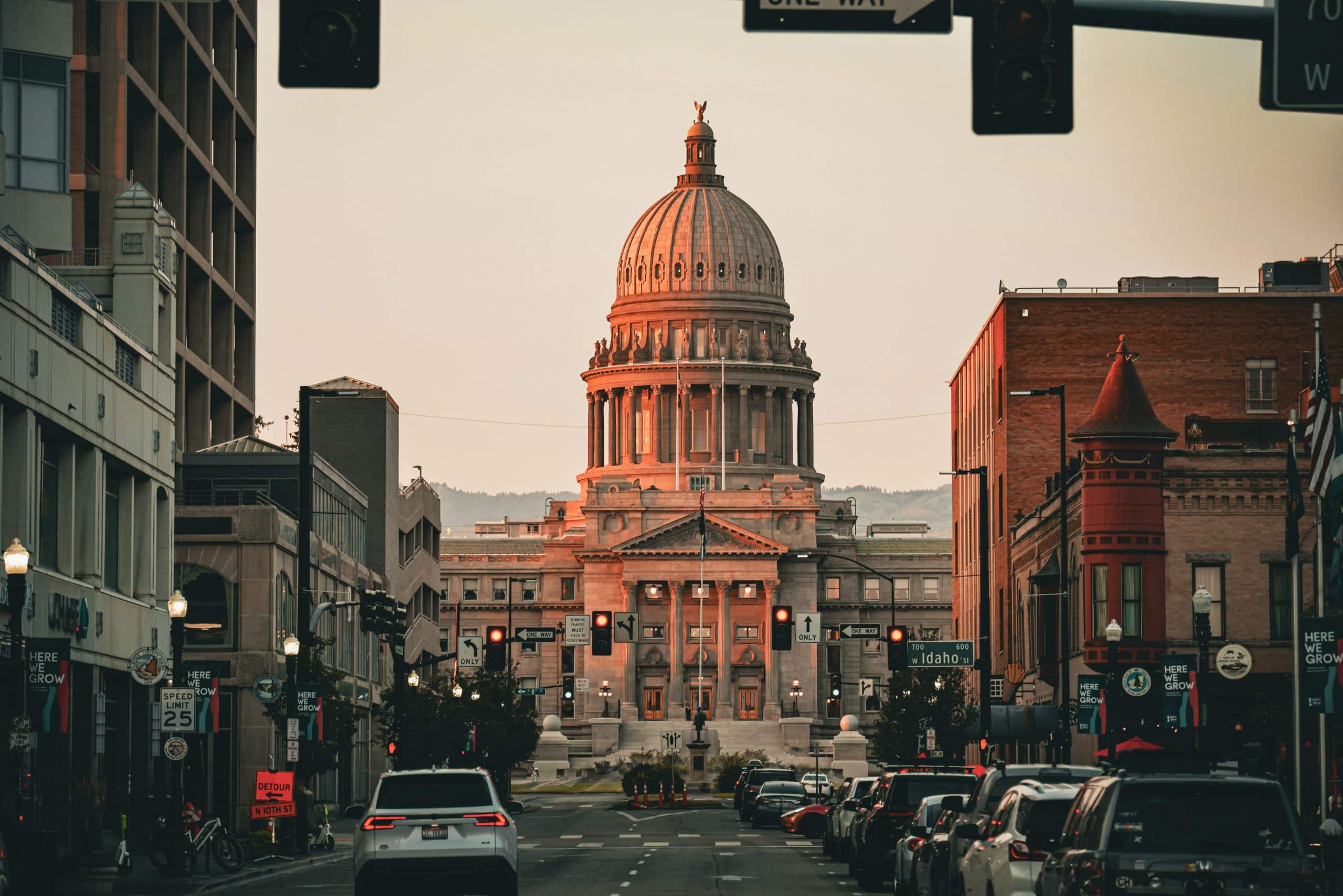 Downtown Boise Idaho street view with the Idaho State Capitol building at sunset and the Treasure Valley foothills in the background