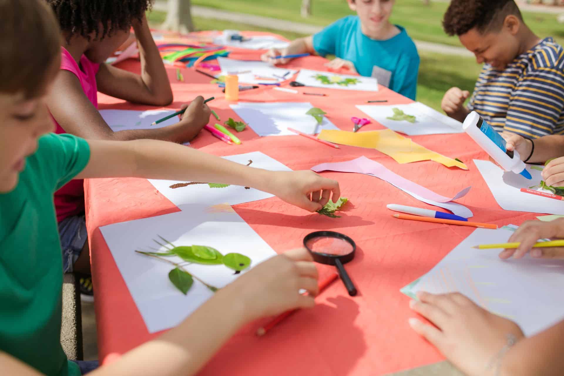 Children doing crafts together at a table, the kind of supervised kids space set up for on-site event childcare